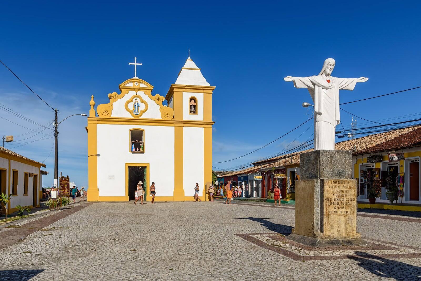 Igreja de Nossa Senhora d'Ajuda e a praça de pedra portuguesa no centro histórico de Arraial d'Ajuda, Bahia